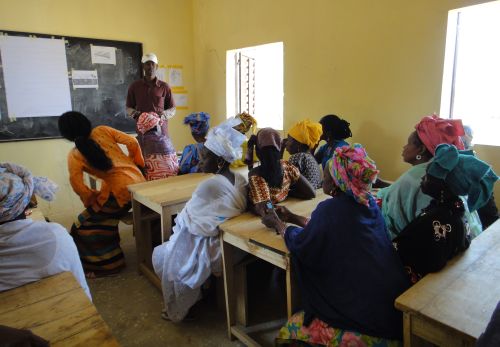 Women in the classroom learning about seeds and planting techniques.